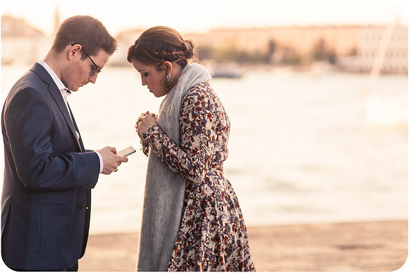 Couple kissing by the water with St. Mark’s Basilica in the background.