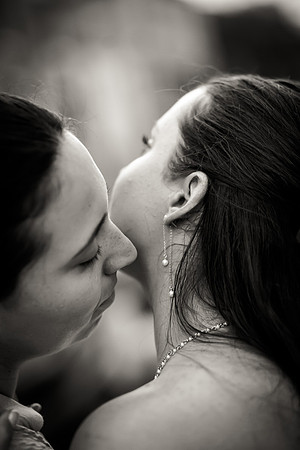 Same-sex couple sharing a close kiss, black and white photography.